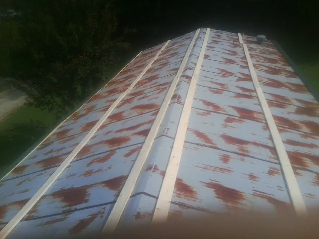 Rusted metal roof panels with new wood purlins before replacement — Storm Damage Roof Repair in Mc Ewen by Roofing Brothers