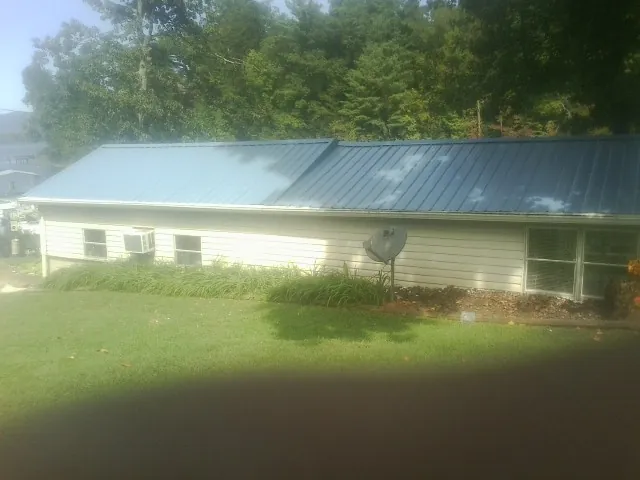 Blue metal roof running the length of a single story home in Mc Ewen