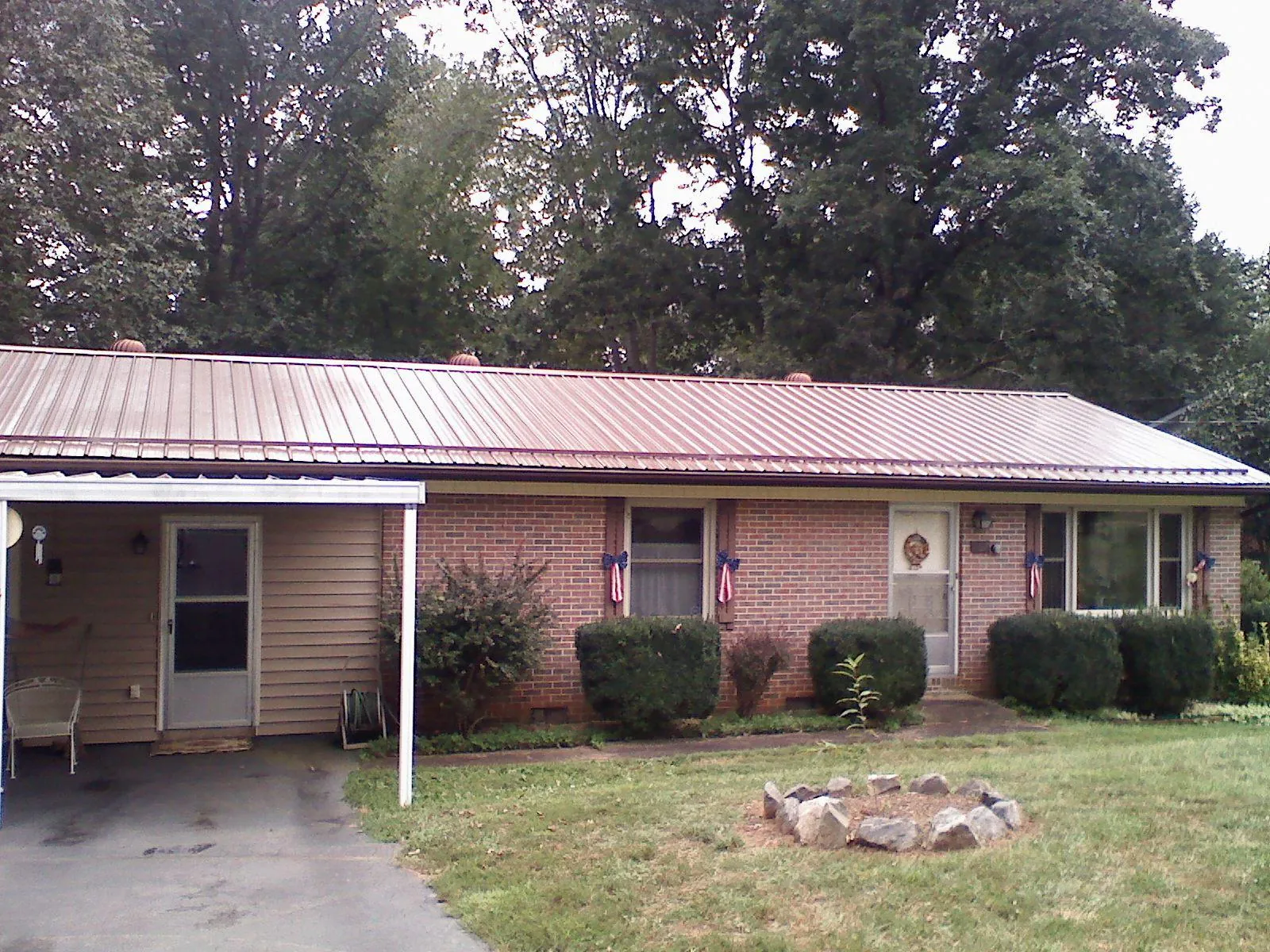 Bronze metal roof and carport on a brick ranch home — Roof Repair work by our crew in Mc Ewen